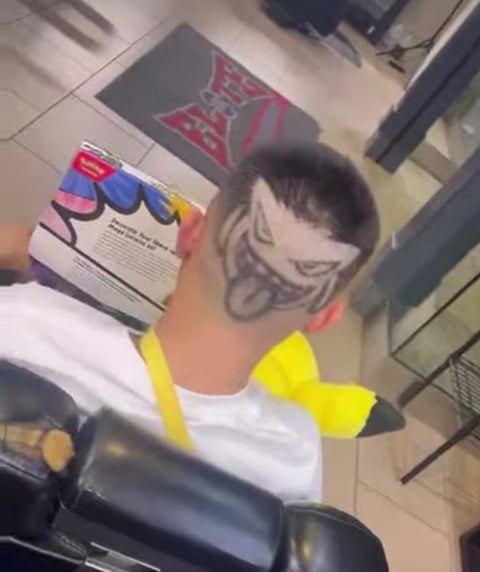 Person wearing neon yellow bow tie and white shirt with graphic design artwork visible in background